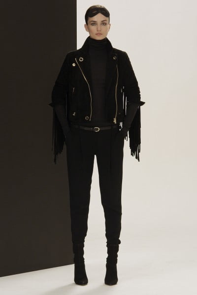 Black suede jacket with fringe. Underneath a black rib wool turtleneck. Tapered masculine pant in black crepe viscose. Skinny black leather belt. Black stretch suede ankle boots